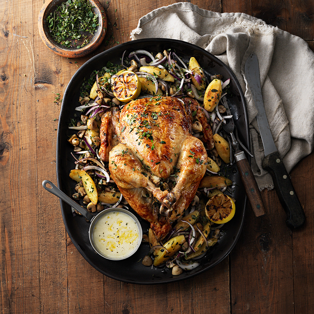 Ugnsgrillad-hel-kyckling-med-rostad-mandelpotatis-och-champinjoner,-citronsky
